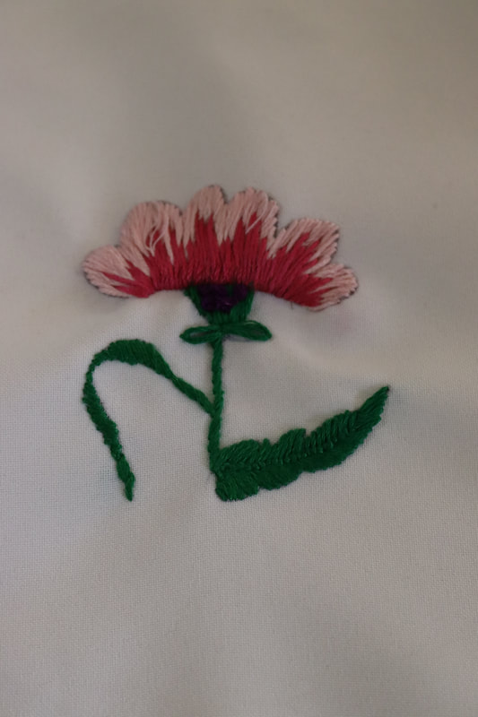 Two shades of pink stitched flower with green stitches